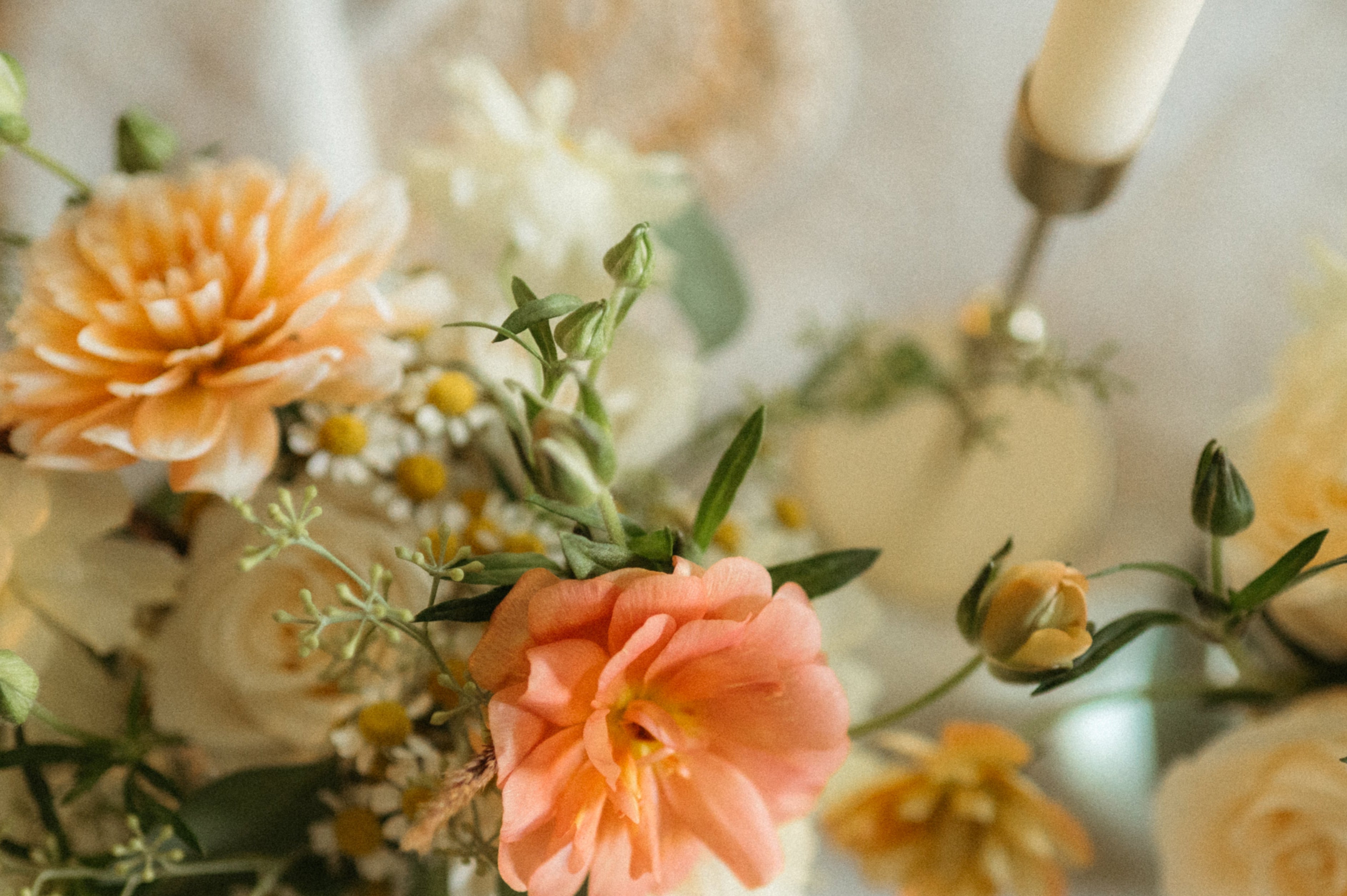 Decorative floral arrangement with peach and yellow flowers on a textured surface