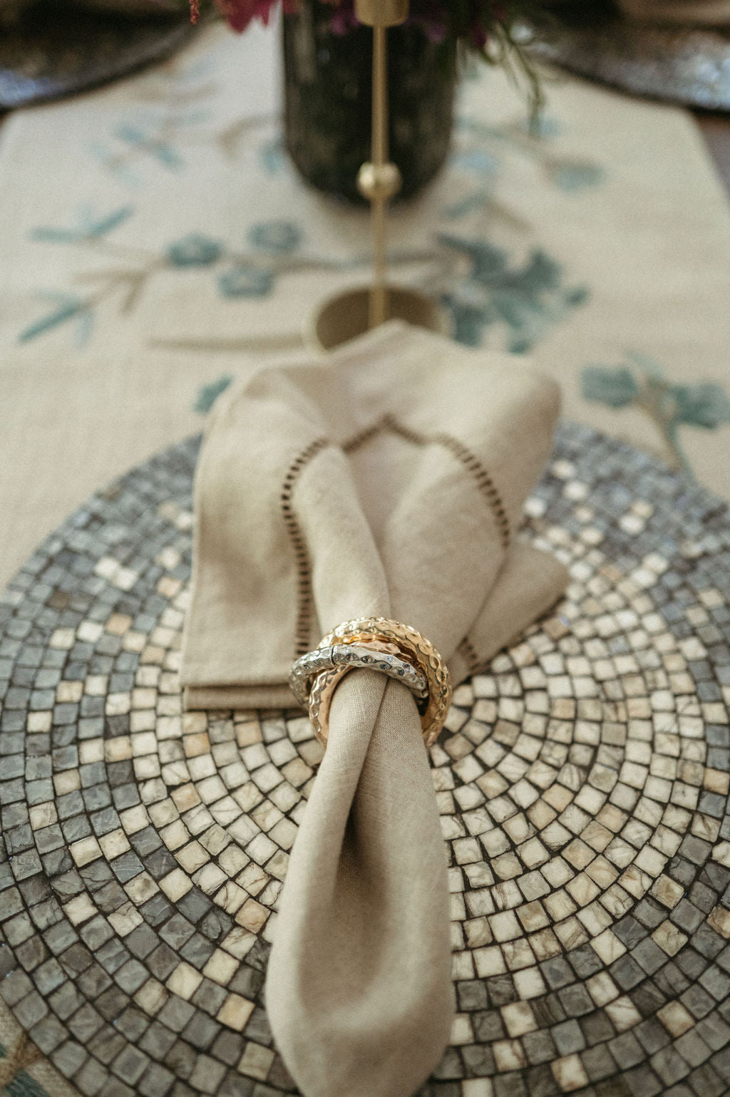 Napkin folded on a mosaic table with a ring on top