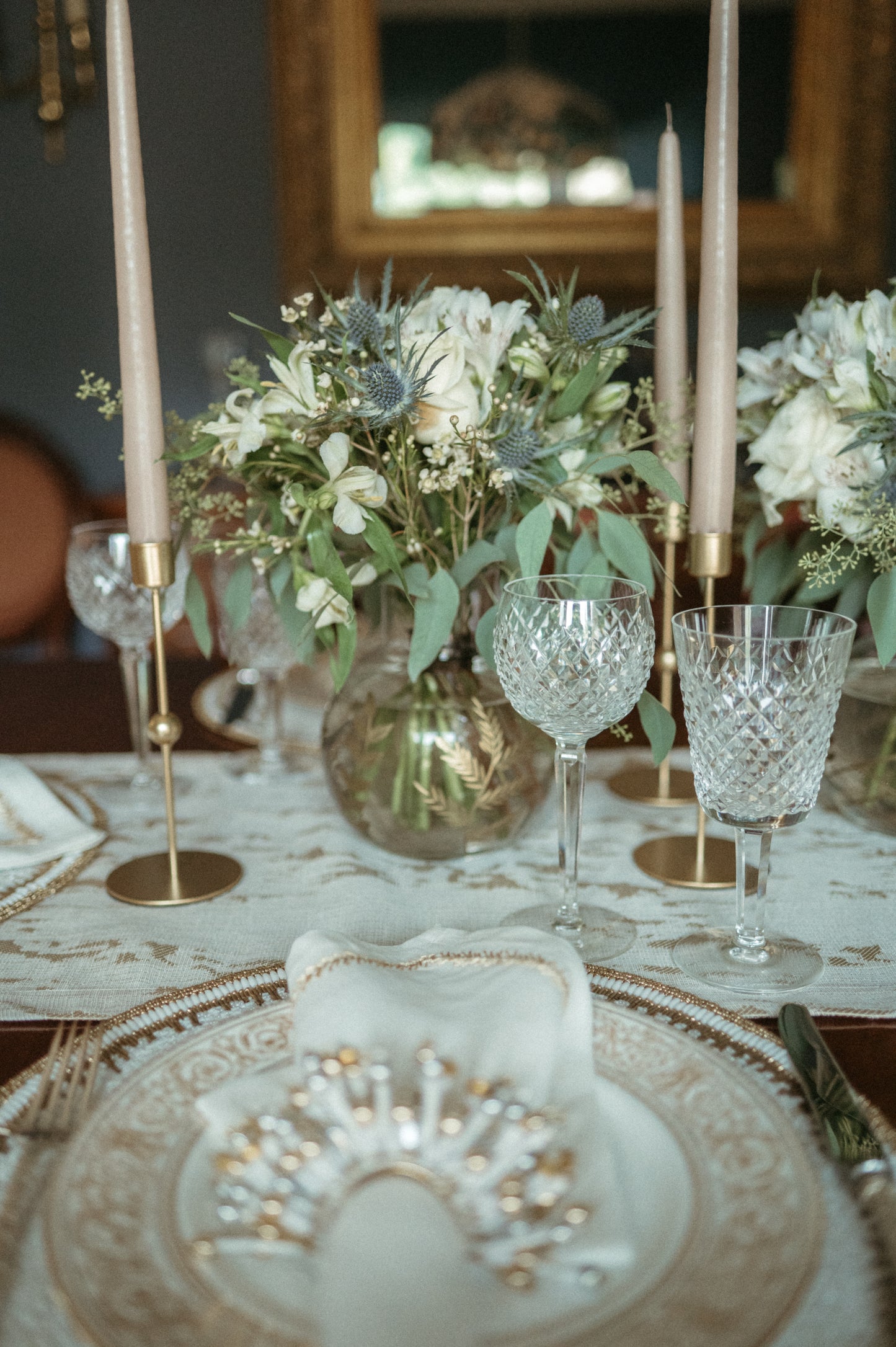 Elegant table setting with floral arrangements, crystal glasses, and candles.