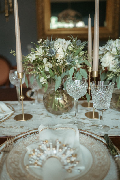 Elegant table setting with floral arrangements, crystal glasses, and candles.