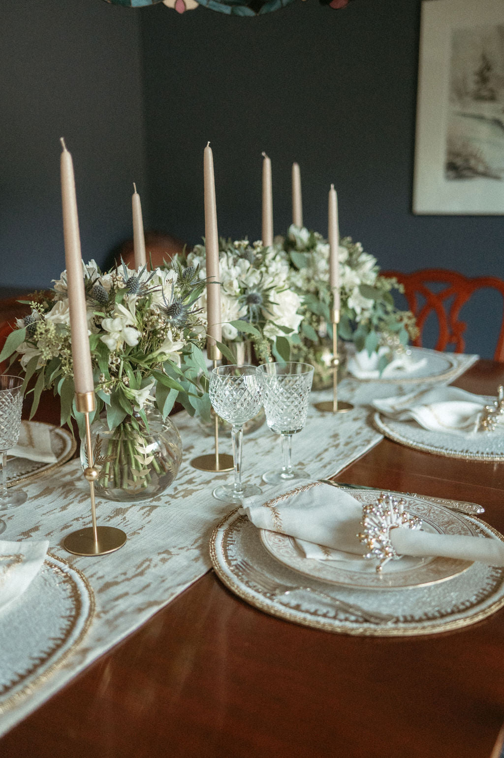 Elegant table setting with floral centerpiece, candles, and fine china.