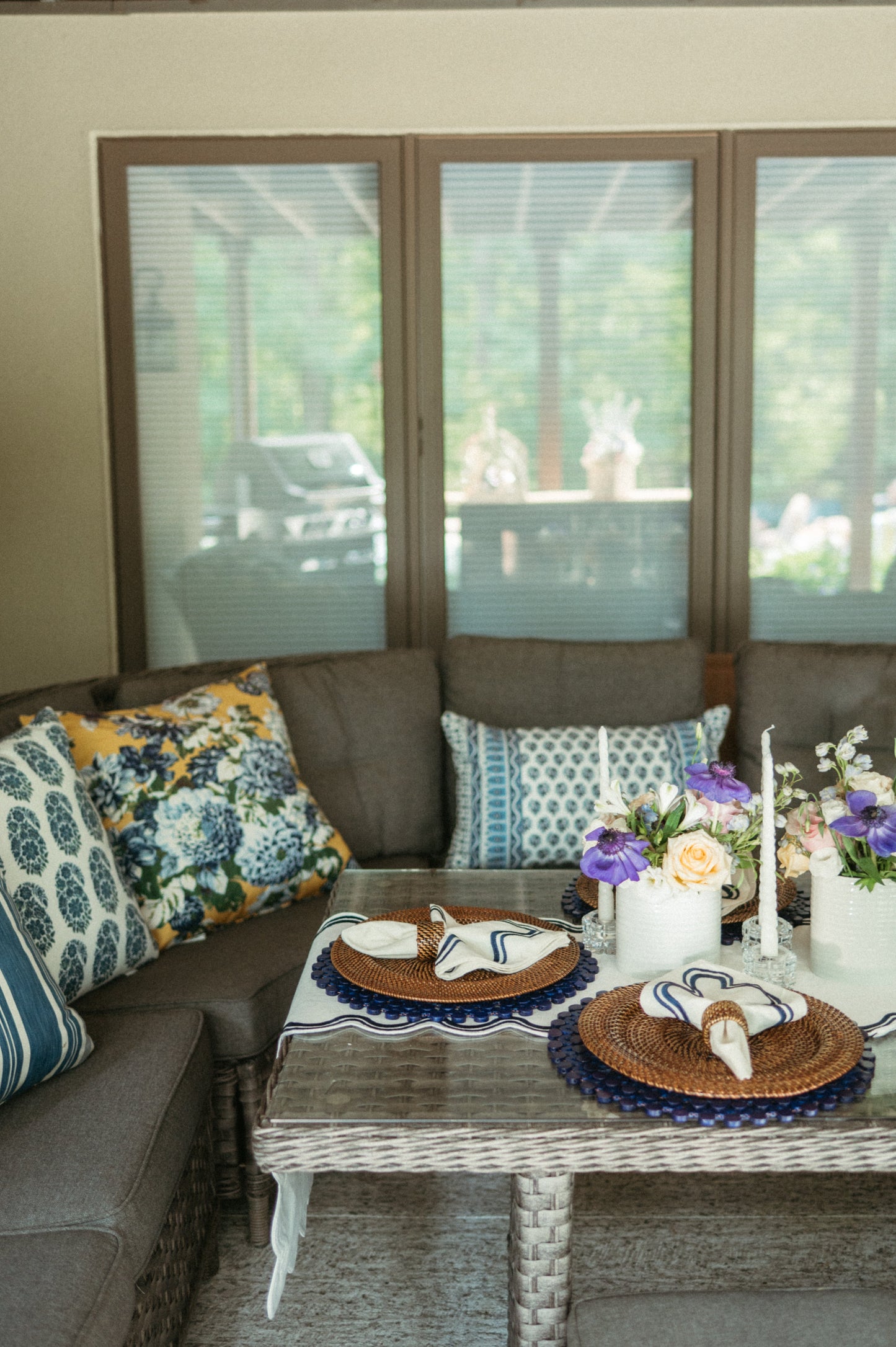 Living room with a sectional sofa, decorative pillows, and a coffee table with a floral arrangement and candles.