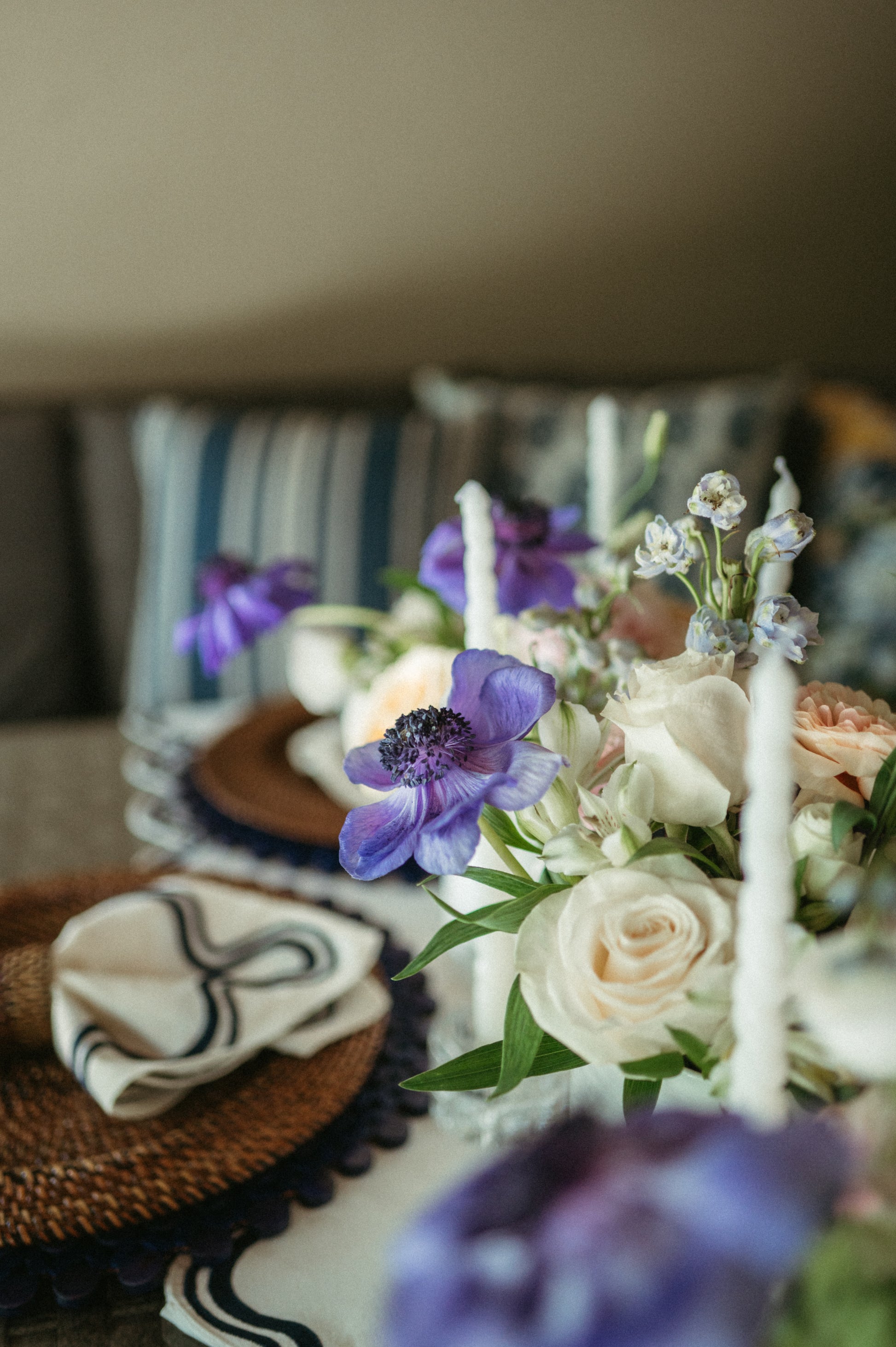 Decorative floral arrangement with candles on a table, with a blurred background