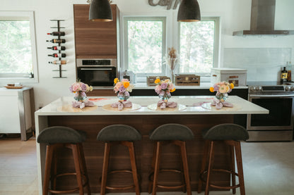 Modern kitchen with a island and bar stools, featuring decorative elements.