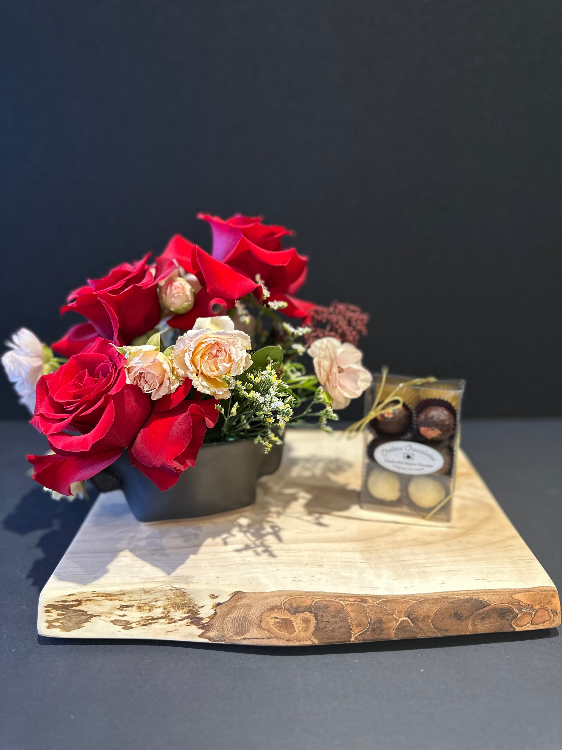 Bouquet of red and white roses on a wooden board with a dark background